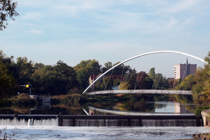 Arch bridge over river against sky
