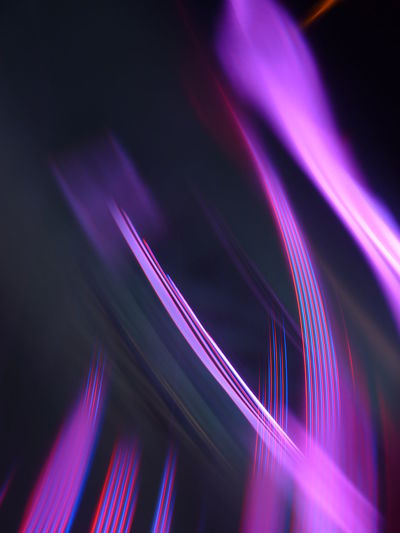 Low angle view of light trails against black background