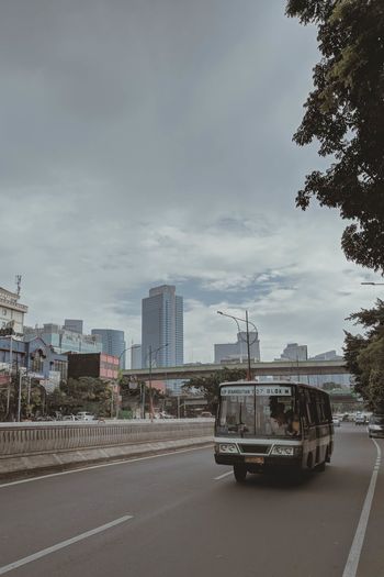 Cars on road in city against sky