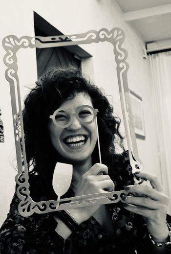 Portrait of a smiling young woman holding camera