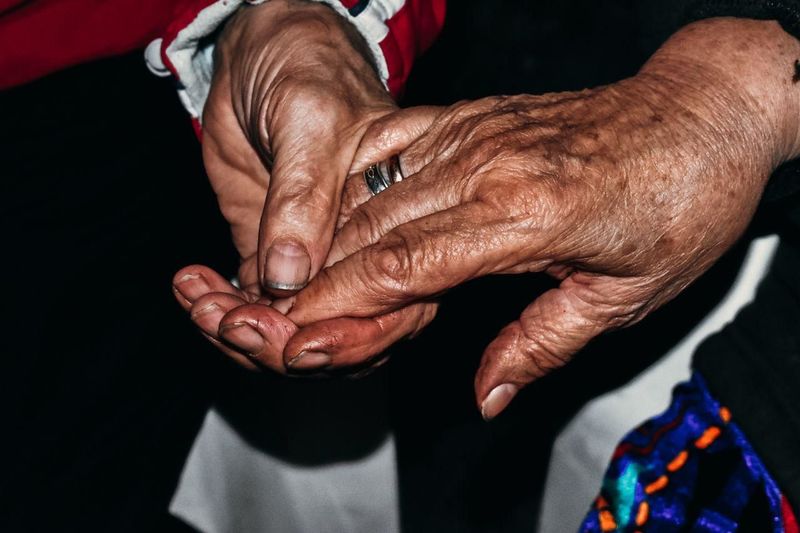 Close-up of hands on woman against black background