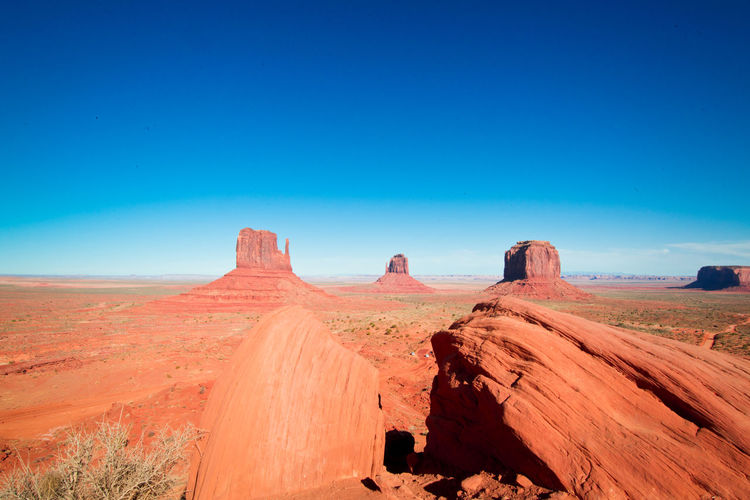 Rock formations at monument valley against clear blue sky