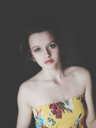 Portrait of girl in yellow dress against black background