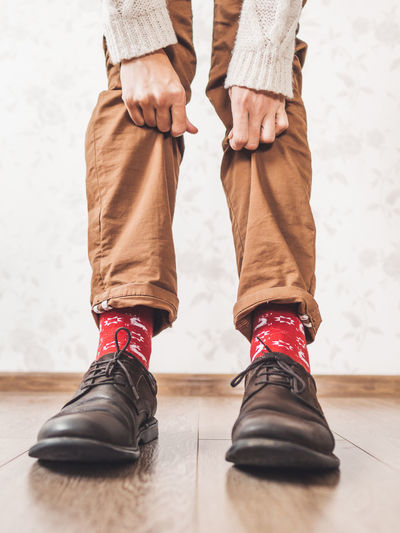 Young man shows bright red socks with reindeers.casual outfit for new year and christmas celebration