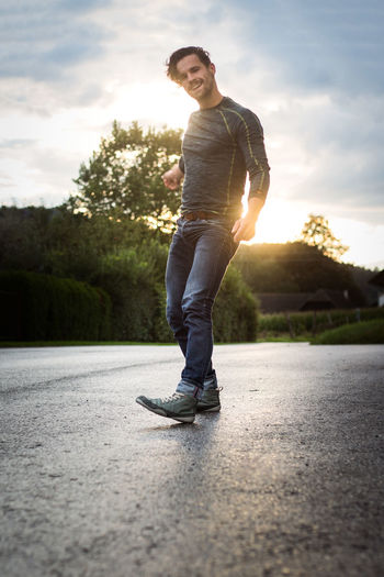 Full length of young man skateboarding on skateboard against sky
