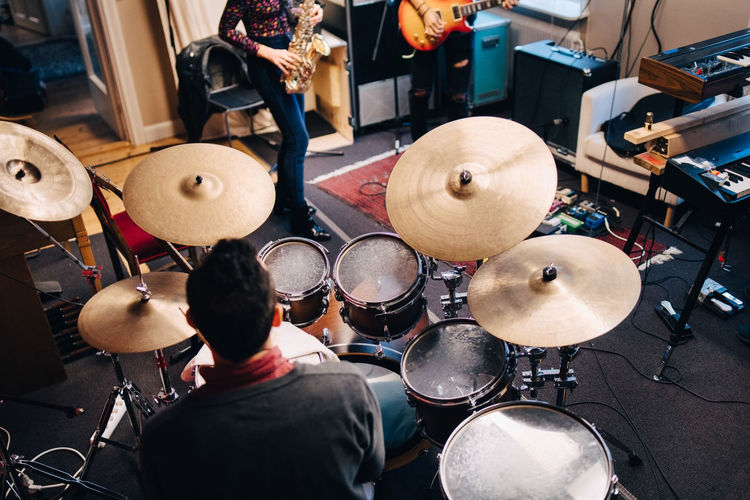 High angle view of friends playing musical instruments at studio