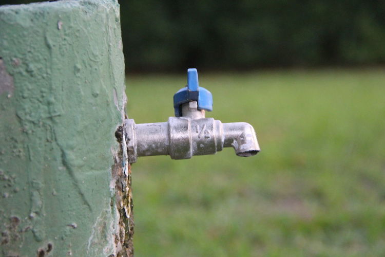 Close-up of old faucet on field