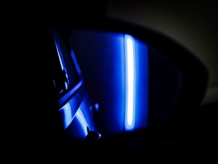 Close-up of illuminated blue light in dark seen through car window