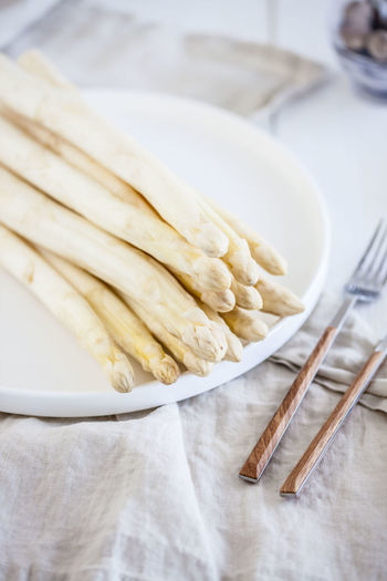 High angle view of white asparagus in plate on table