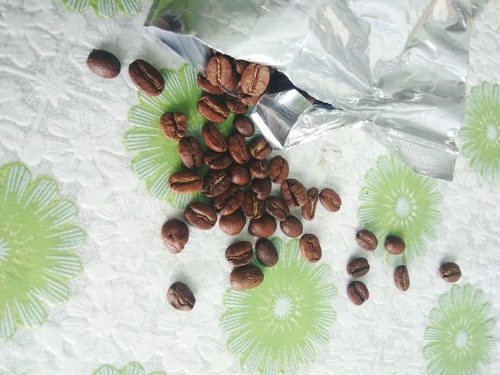 High angle view of coffee beans spilled out on paper towel