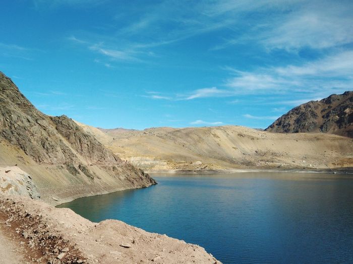 Scenic view of lake and mountains against blue sky