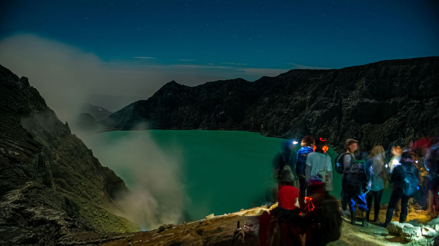 People on mountain against sky at night