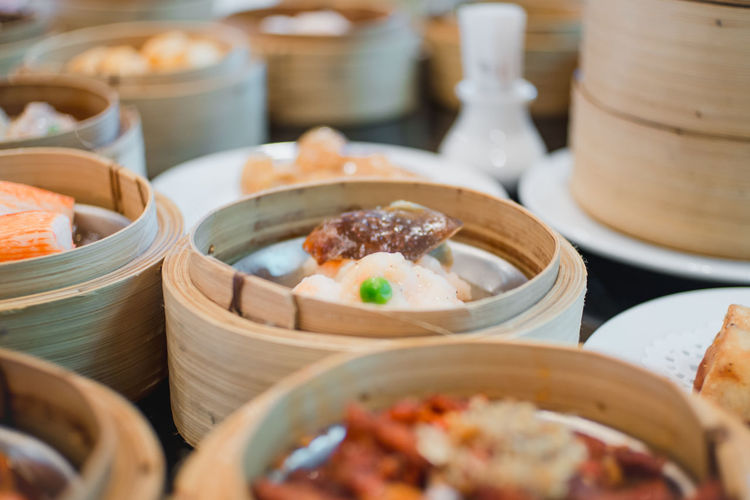 Close-up of dim sums served in steamers on table