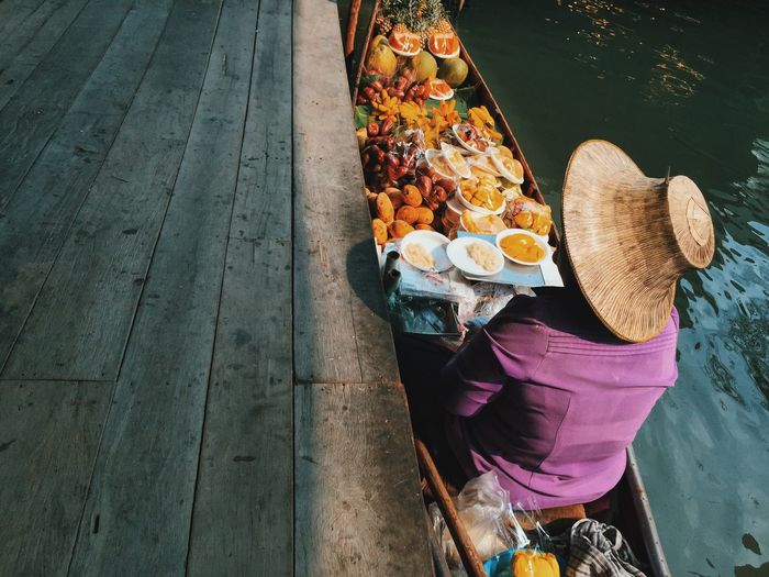 Person in boat with fruits at damnoen saduak floating market