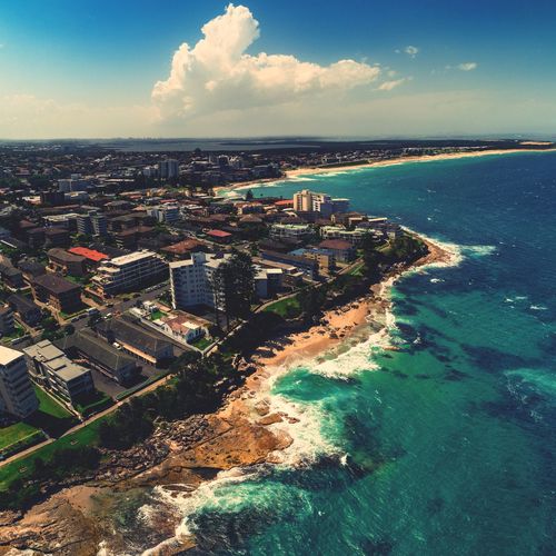 High angle view of townscape by sea against sky