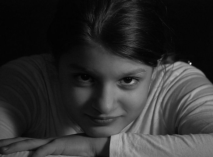 Close-up portrait of beautiful woman against black background
