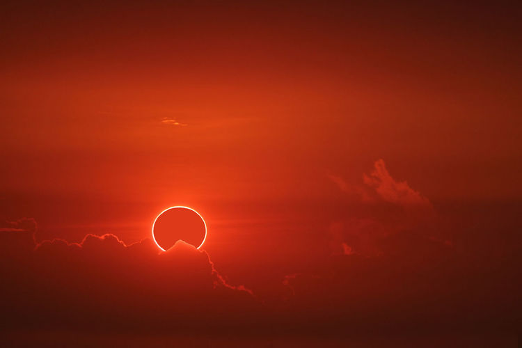 Amazing phenomenon of total sun eclipse over cloud sunset red orange sky on the sea and ocean