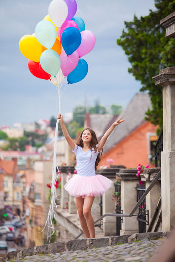 Full length of woman holding colorful balloons