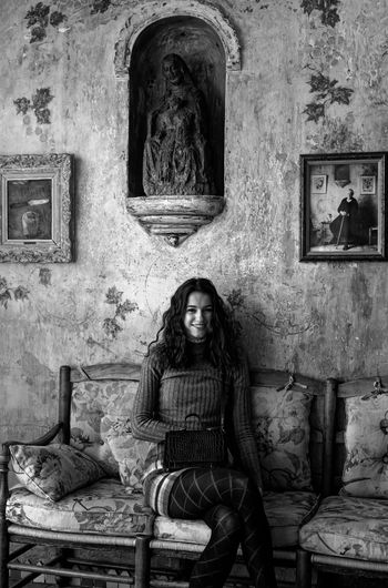 Portrait of woman sitting inside old abandoned house