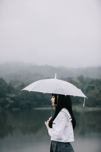 Woman with umbrella standing in rain