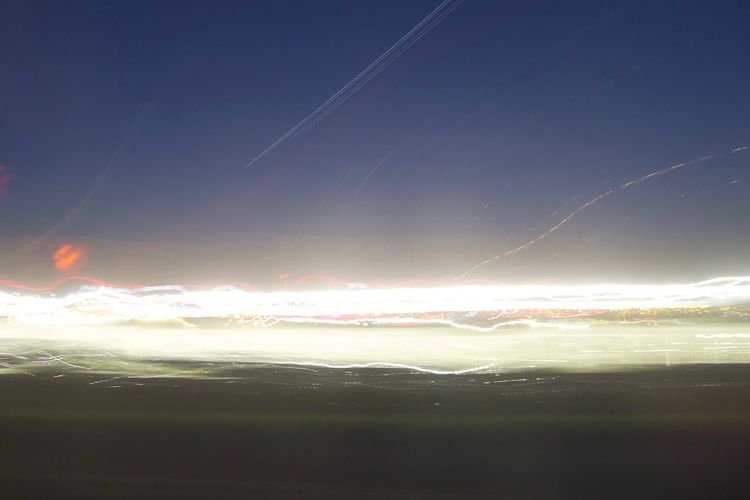 Scenic view of vapor trails in sky at sunset