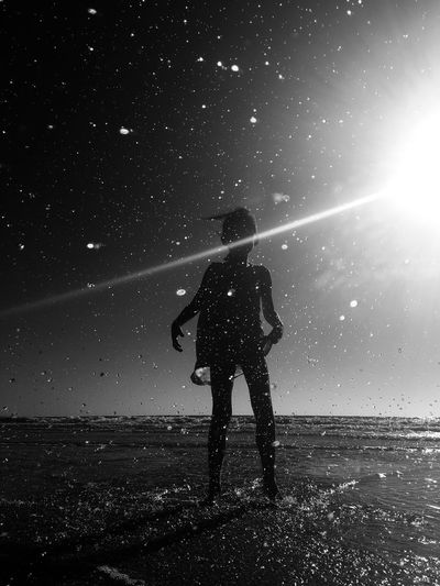 Silhouette girl standing on beach against sky