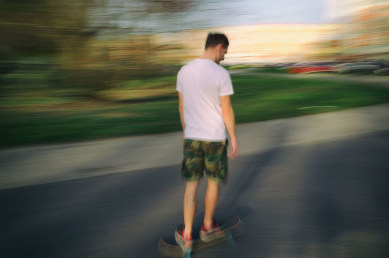 Rear view of siblings standing on road