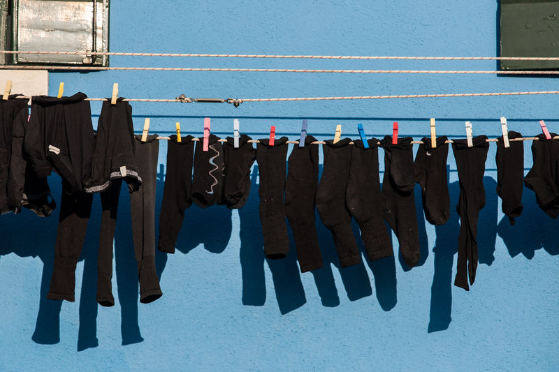 Laundry drying on clothesline against wall