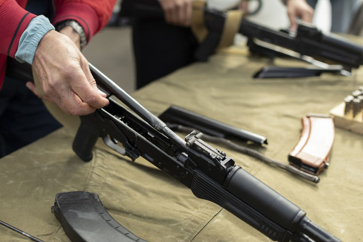 A man disassembles a firearm. a person undergoes military training. 