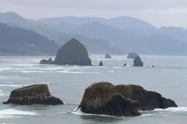 Scenic view of sea and mountains against sky
