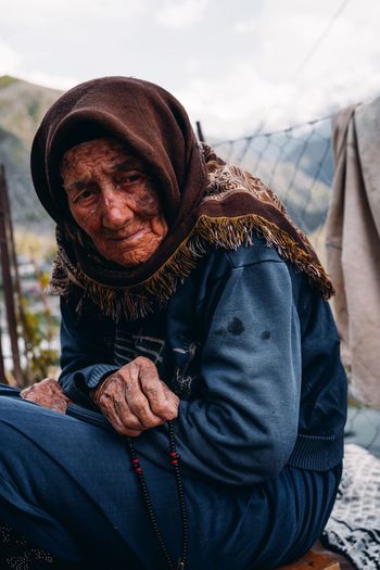 Senior woman sitting outdoors during winter