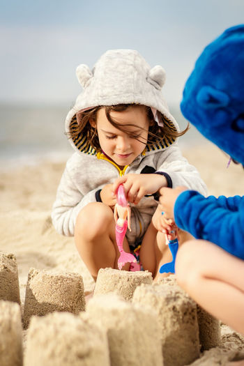Sisters making sandcastle at beach