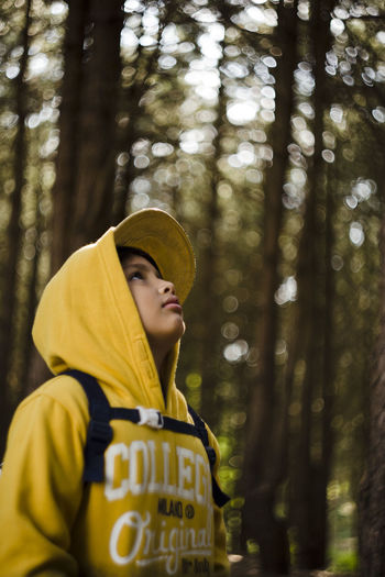 Teenage boy looking away in forest