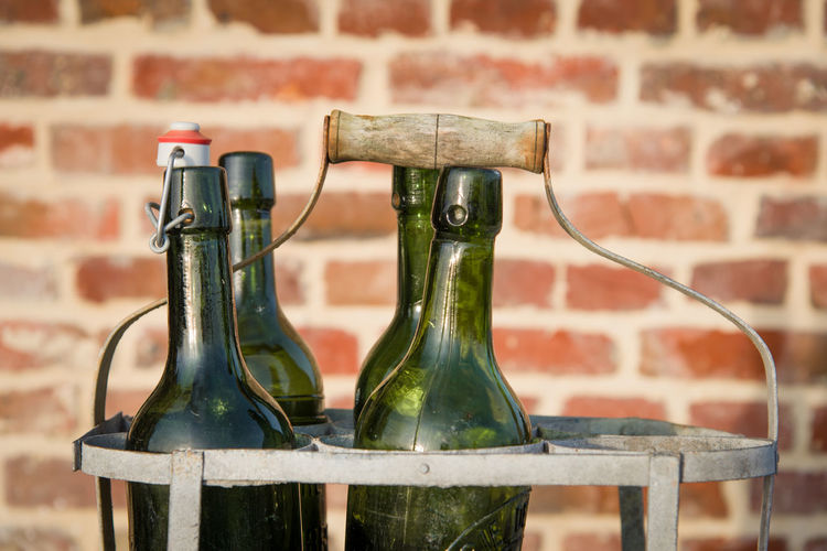 Close-up of beer bottle against wall. close-up of wine bottle against wall. 