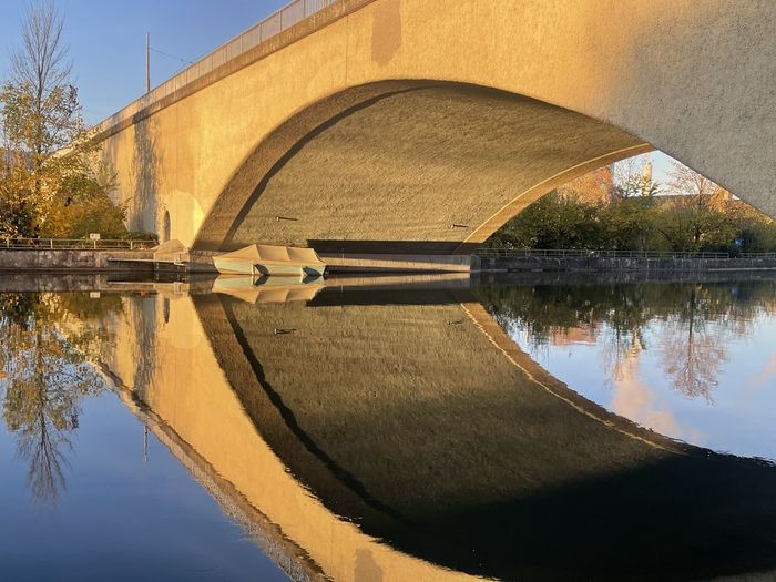 Arch bridge over lake against sky