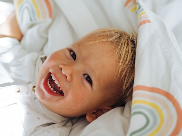 Portrait of smiling boy lying on bed