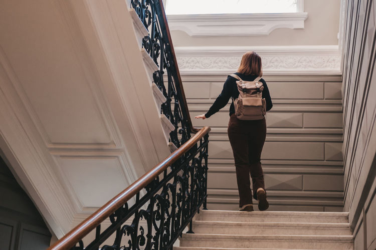 Check-in at the hotel of a traveler with a backpack. the woman climbs the stairs.