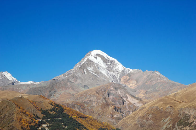 View of mount kazbek in the greater caucasus mountains of georgia in autumn time.