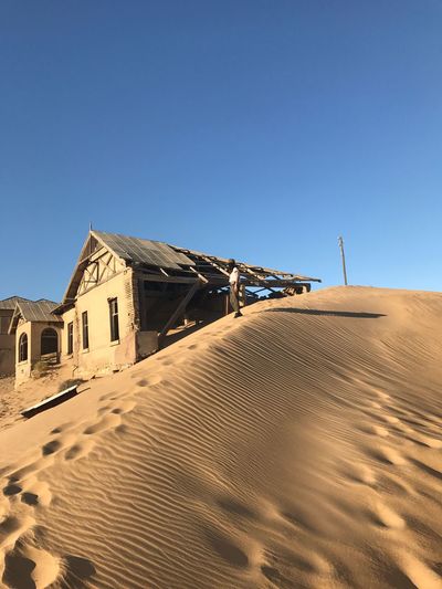 Houses in desert against clear blue sky