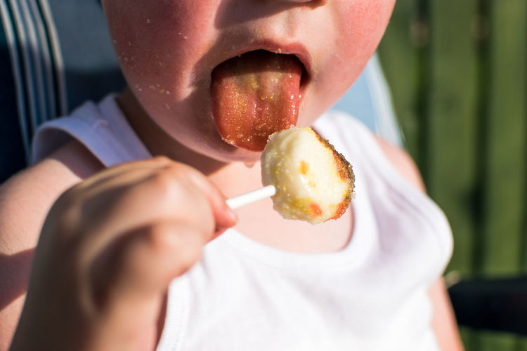 Midsection of boy eating lollipop