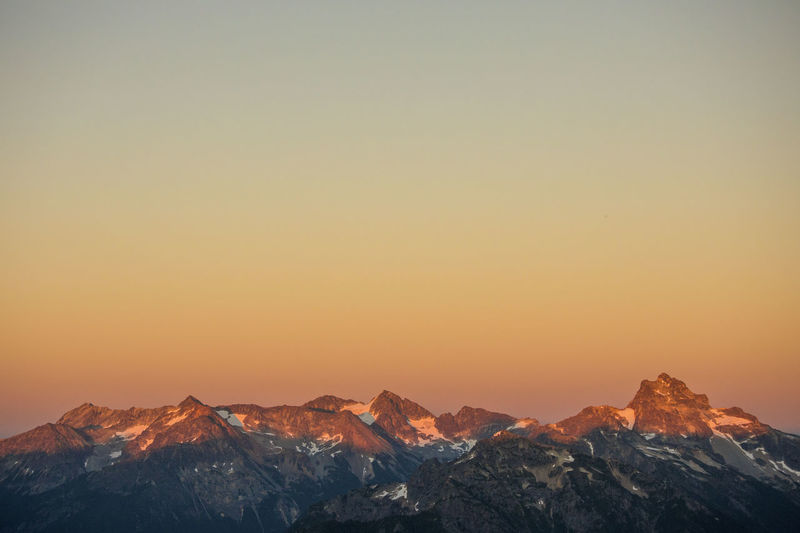 Scenic view of snowcapped mountains against sky at sunset