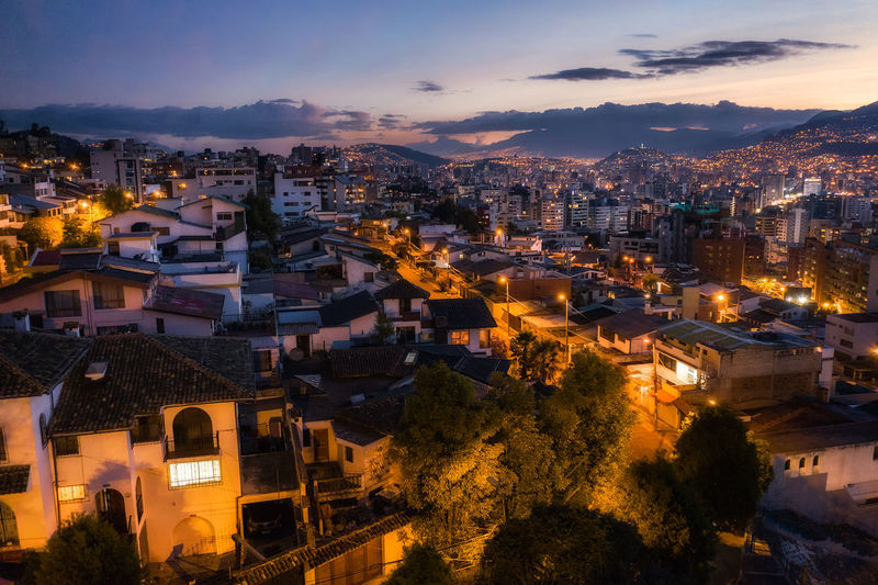 High angle view of illuminated buildings in city at sunset