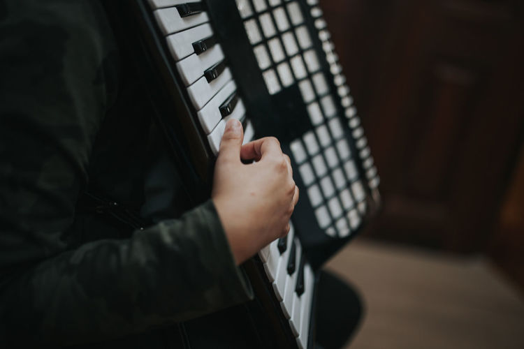 Midsection of man playing accordion