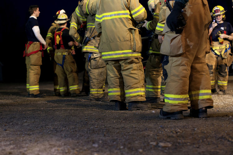Firefighters standing on field at night