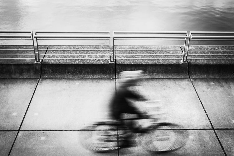 Blurred motion of man riding bicycle on railing