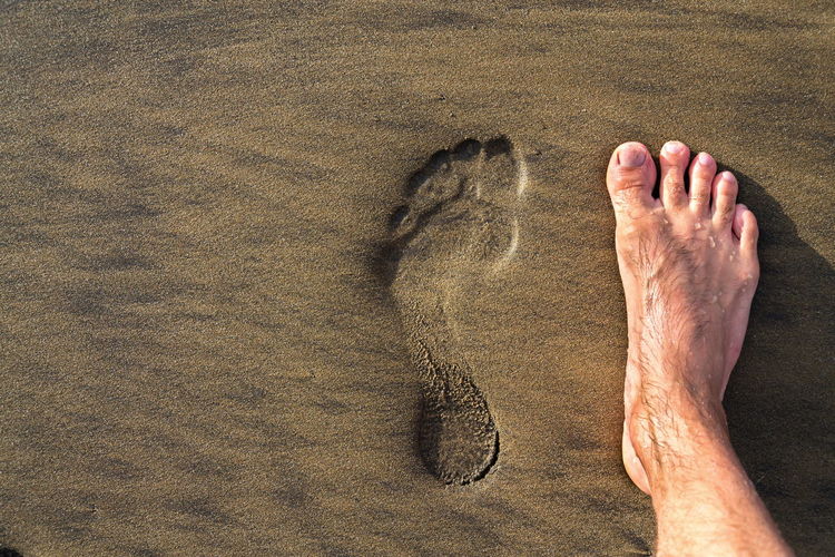 Low section of man legs on sand