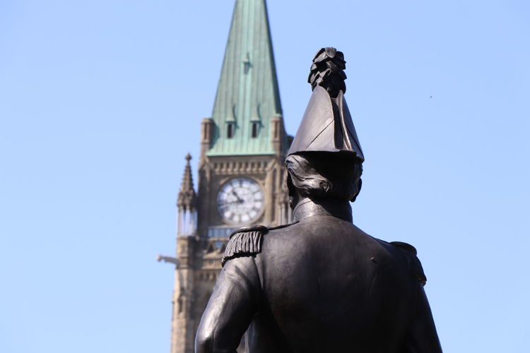 Low angle view of statue against canadian parliament