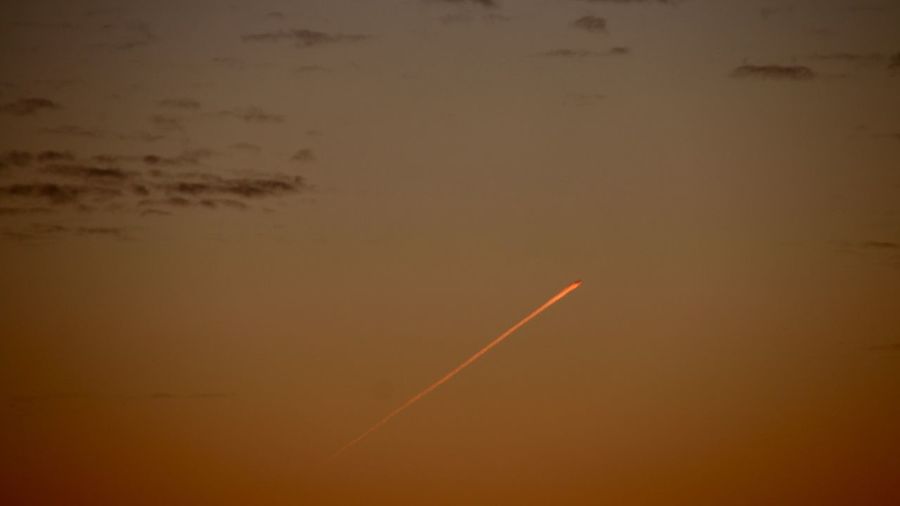 Scenic view of vapor trails in sky during sunset