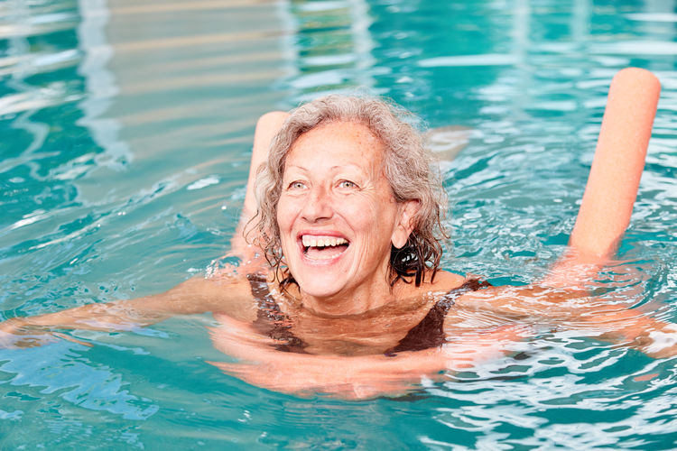 Portrait of smiling young woman swimming in pool