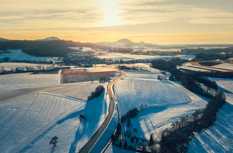 High angle view of snow covered landscape during sunset